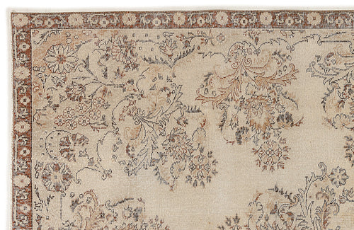 Load image 1 in gallery view. The Tefaas Vintage Floral Rug (6'8 x 9'7) has a beige background with intricate floral and vine patterns in muted brown, rust, and gray tones, finished with a decorative border.