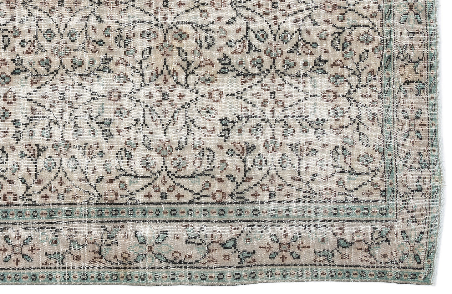 Beige vintage-style rug with a distressed floral pattern in muted teal and brown, featuring a decorative border.