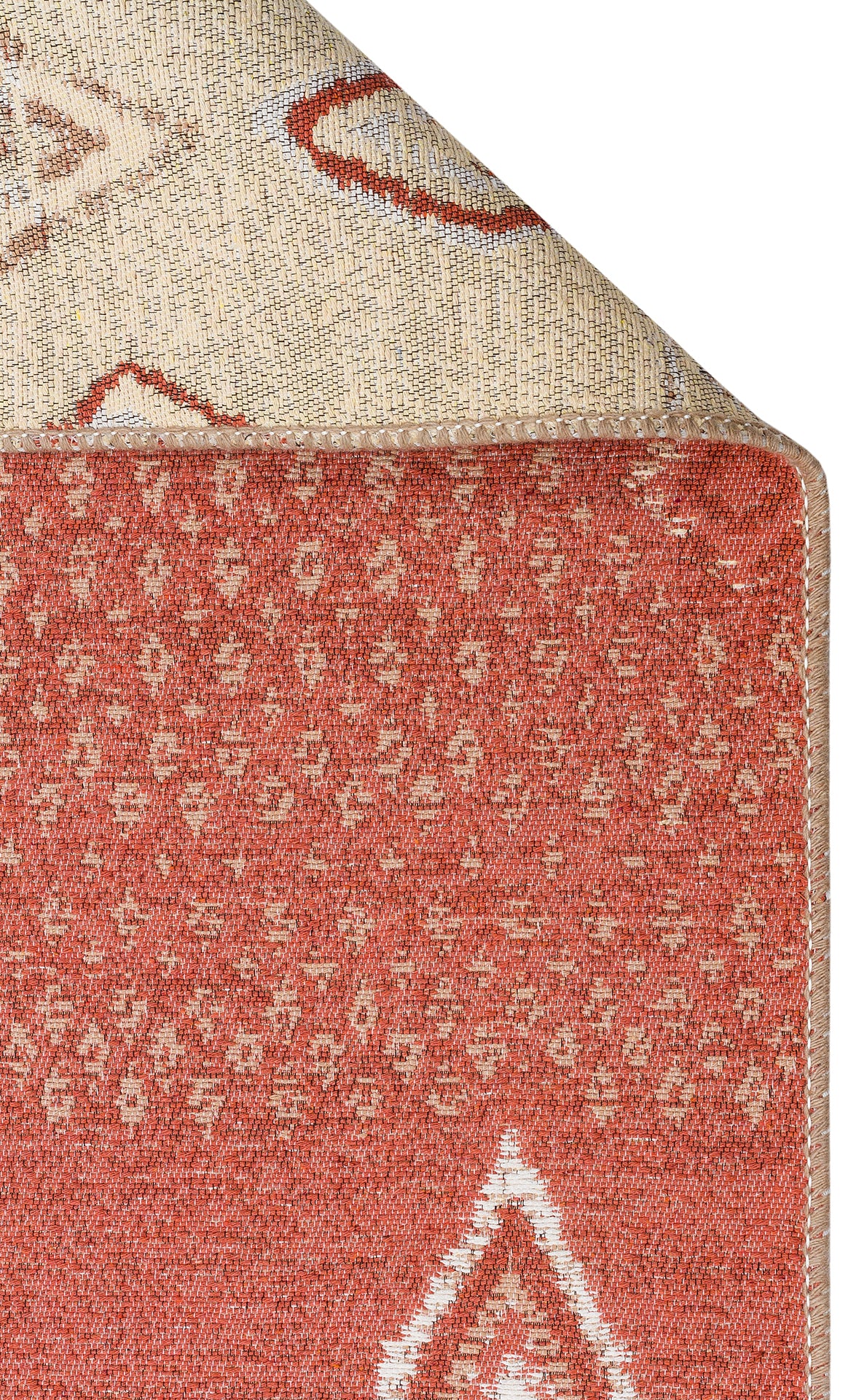 A close-up of the Clay Blend - Washable Double-Sided Kilims - AR37 rug in rust tones with cream geometric designs, corner flipped to reveal its lighter patterned underside—ideal for bohemian home decor.