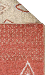 A close-up of the Clay Blend - Washable Double-Sided Kilims - AR37 rug in rust tones with cream geometric designs, corner flipped to reveal its lighter patterned underside—ideal for bohemian home decor.