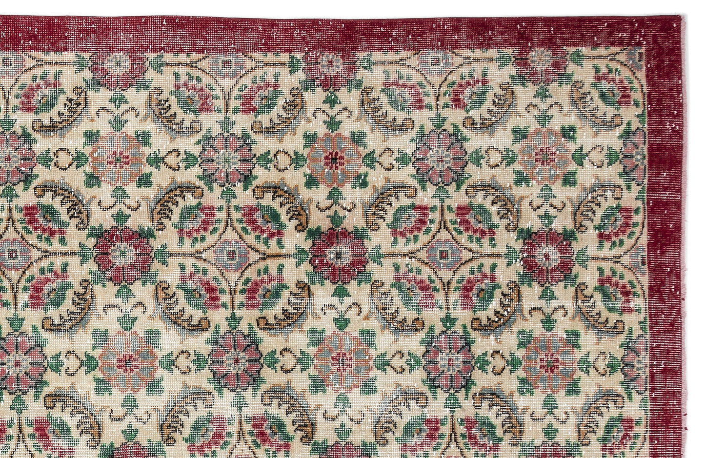 Beige rug with a red border and a repeating floral medallion pattern in red, green, and blue on a white background.