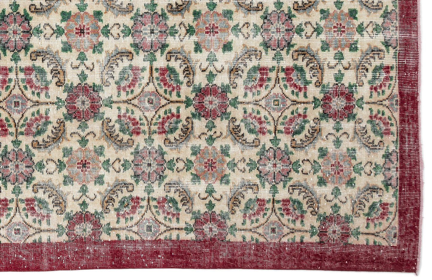 Beige rug with a repeating floral medallion pattern in red, green, and blue, featuring a solid red border.