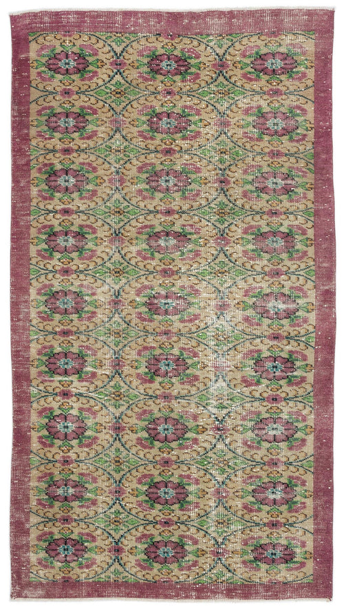 Load image 1 in gallery view. Distressed tan rug with a repeating floral medallion pattern in pink, green, and blue, framed by a solid pink border.