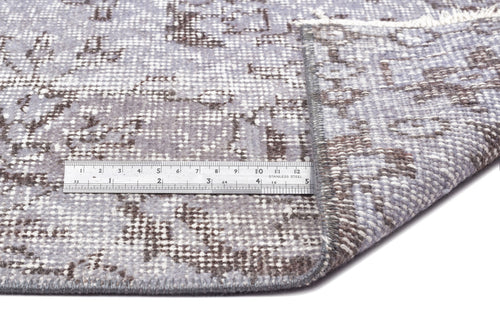Load image 1 in gallery view. Grey and brown distressed floral pattern rug with a folded corner and a stainless steel ruler for scale.