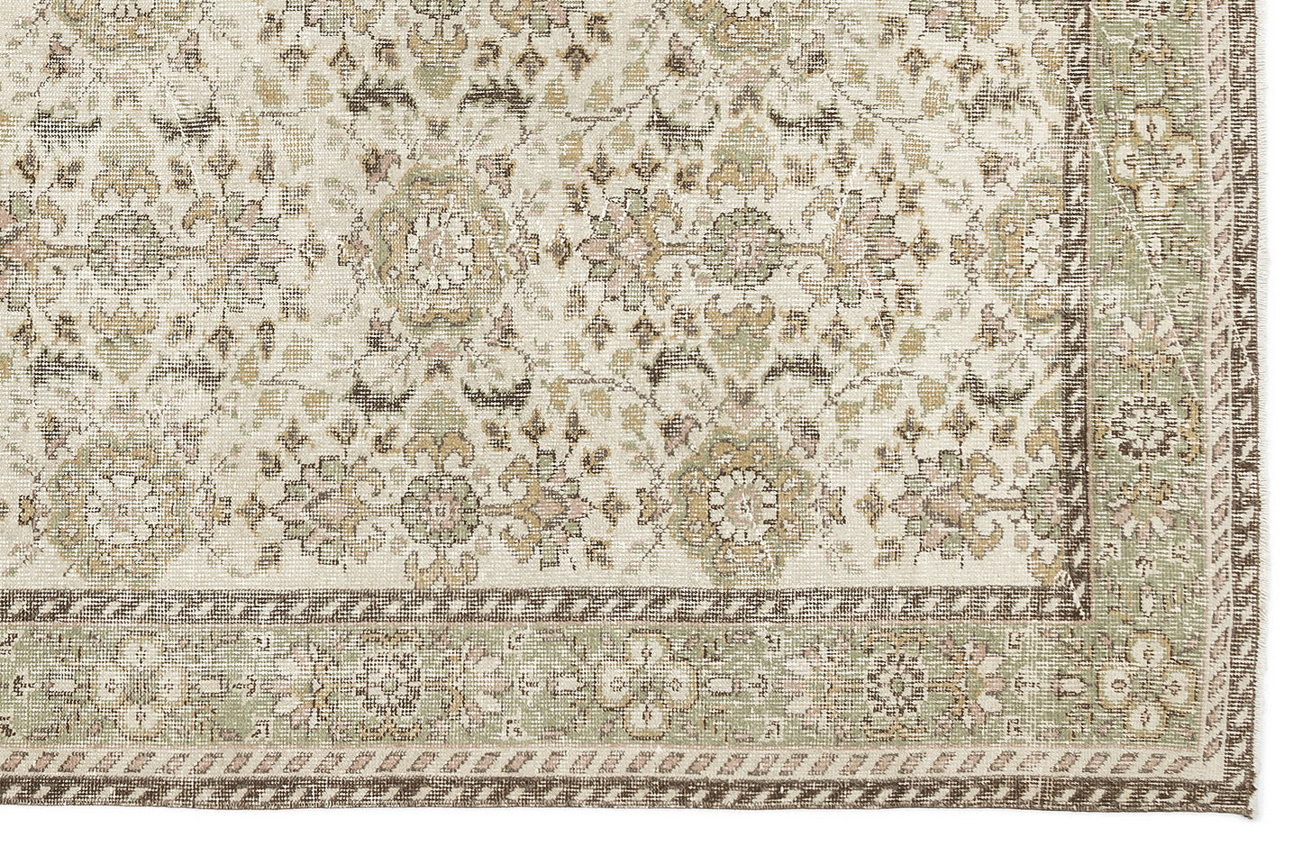 The Nizora - Vintage Floral Rug (6'1 x 10'0) features an ornate, symmetrical floral and geometric design in muted beige, cream, green, and brown tones with a detailed border along the right and bottom edges.