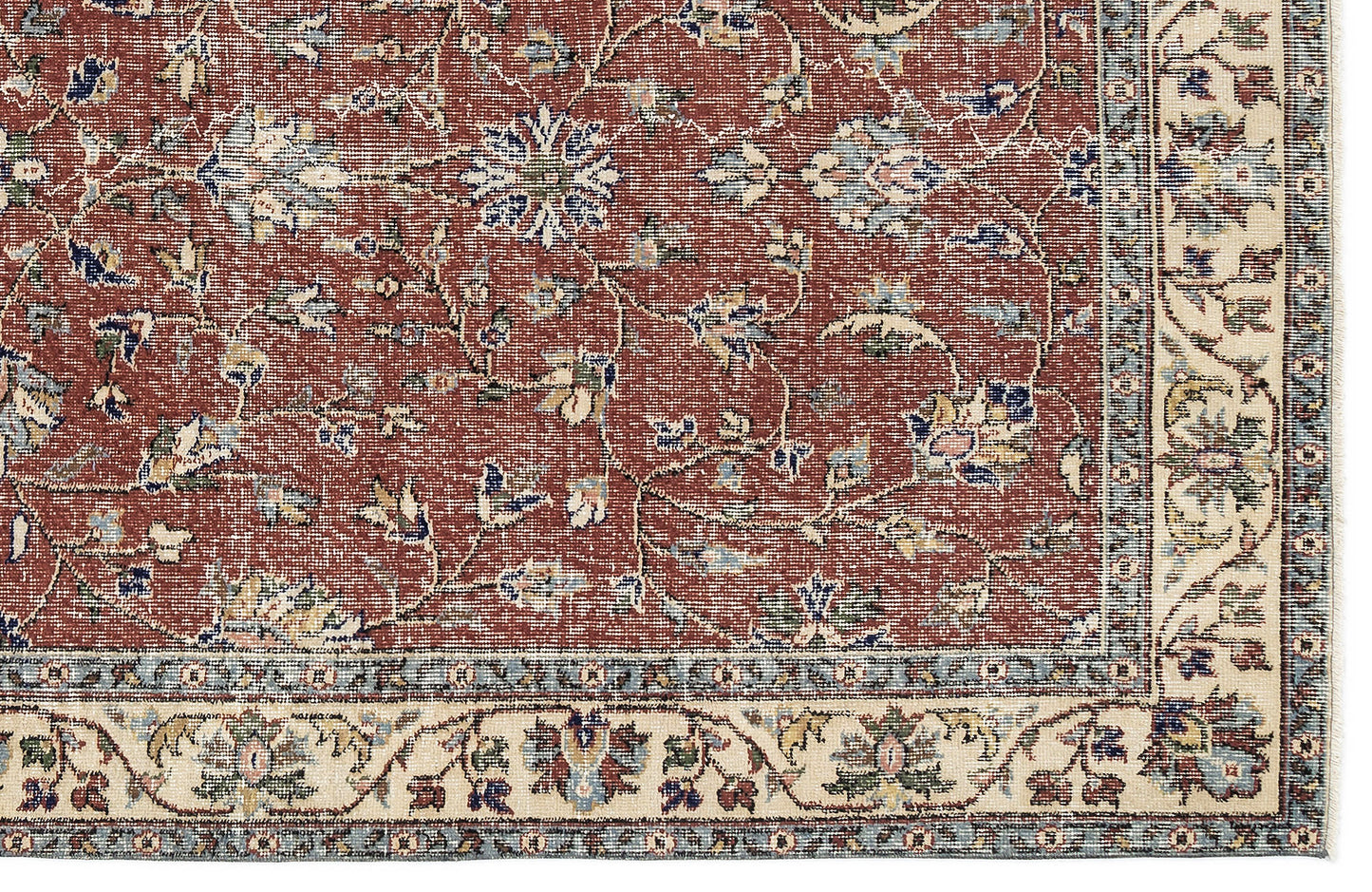 Terracotta rug with a traditional floral vine pattern, blue and cream accents, and a wide cream border.