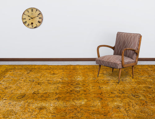Load image 1 in gallery view. Distressed mustard yellow rug with a traditional floral pattern, styled in a room with a vintage chair and wall clock.