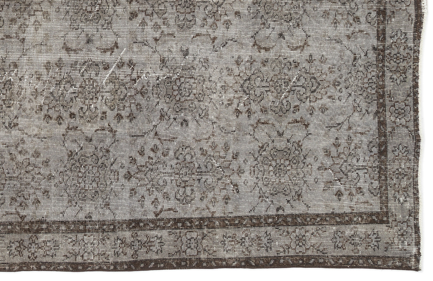 Grey and brown distressed rug with a traditional floral medallion pattern and a wide decorative border.