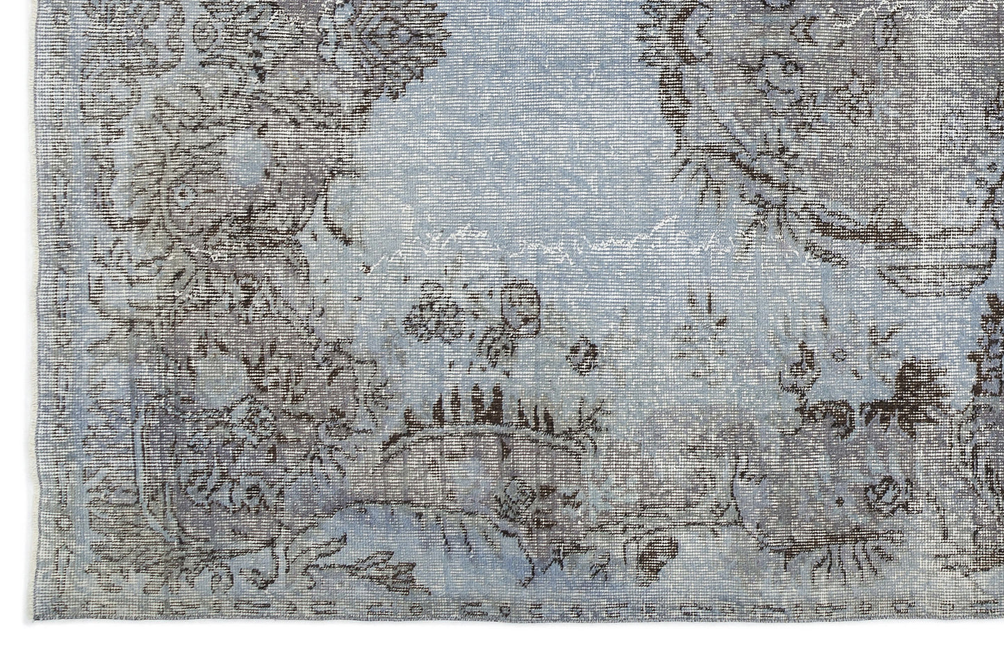 Light blue and charcoal grey rug with a distressed, faded traditional floral medallion pattern.