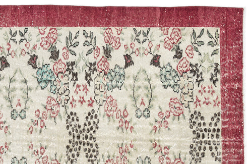 Load image 1 in gallery view. Cream rug with a red border and a distressed floral pattern in shades of red, green, and dark brown.