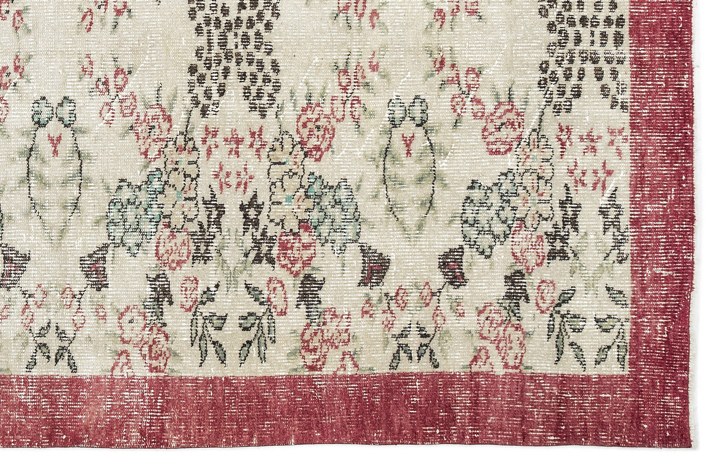 Distressed cream rug with a floral pattern in red, green, and black, featuring a wide red border.