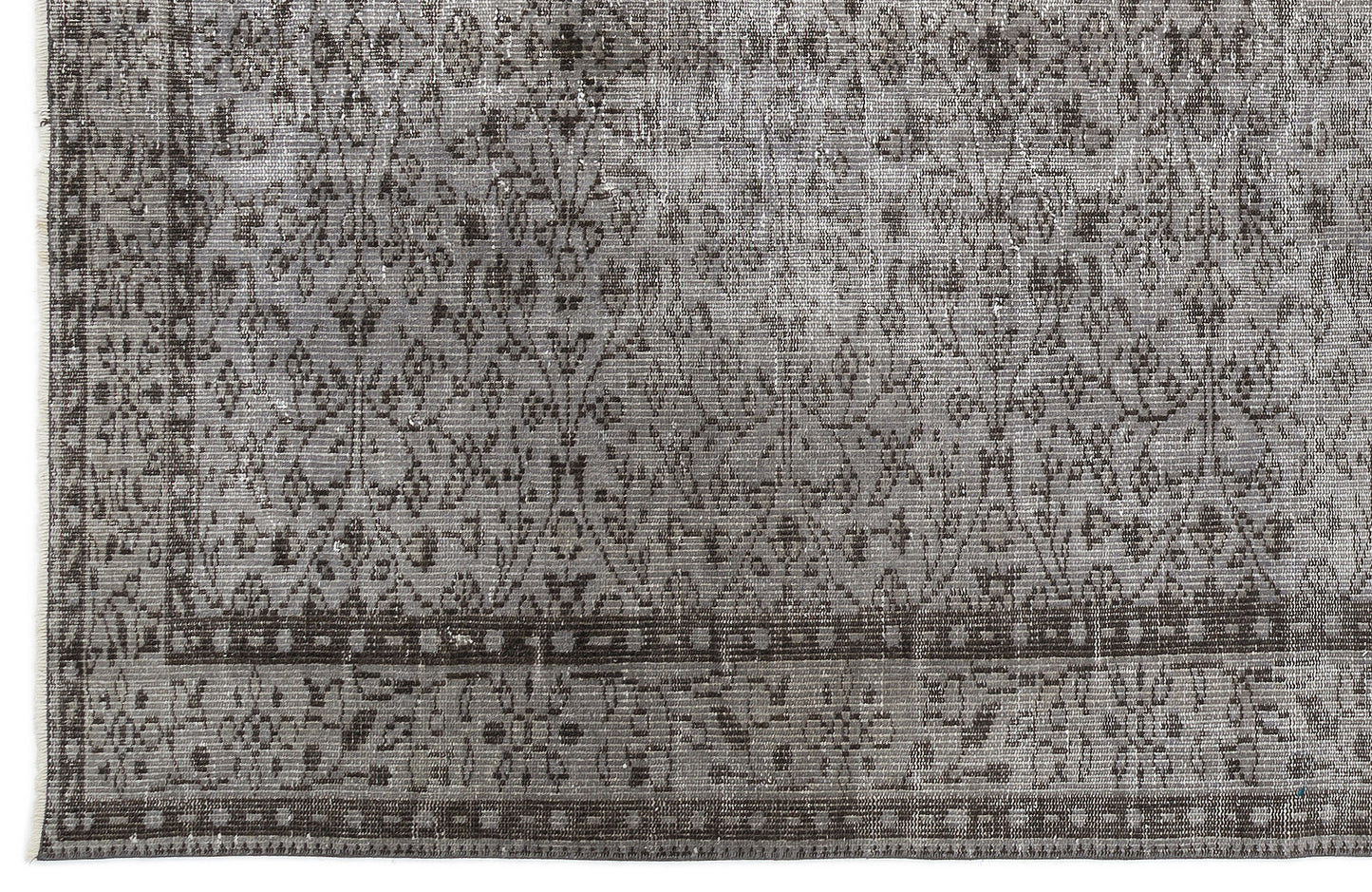 Grey and charcoal distressed rug with a traditional floral medallion pattern and a geometric border.