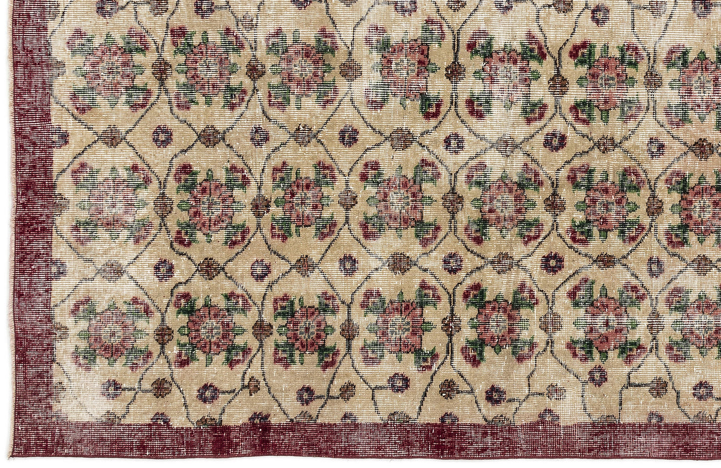 Beige rug with a repeating floral medallion pattern in red and green, enclosed by a dark red border.