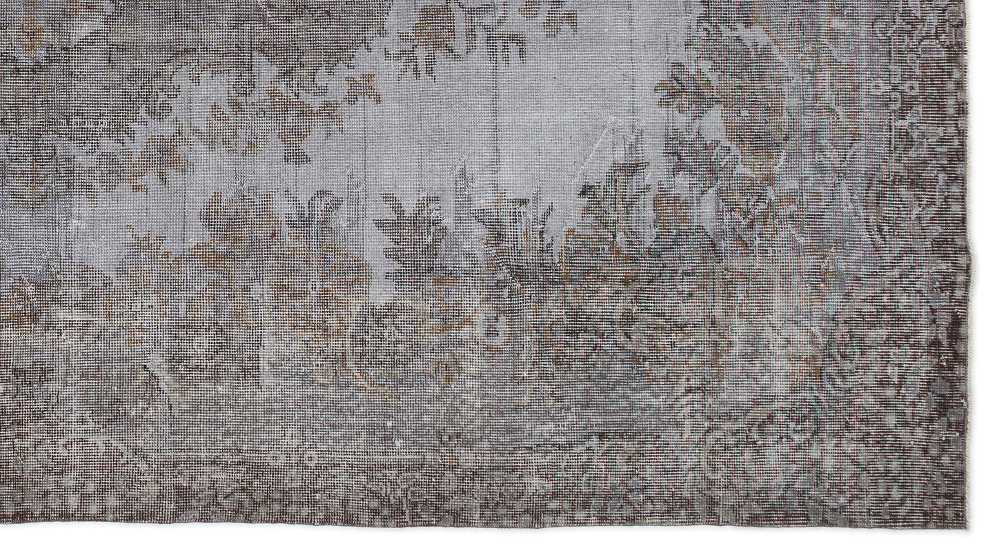 Grey and brown distressed rug with a faded traditional floral medallion pattern on a white background.