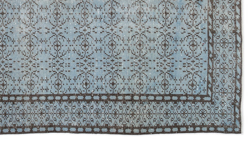 Load image 1 in gallery view. Light blue distressed rug with a dark brown repeating floral medallion pattern and a geometric border.