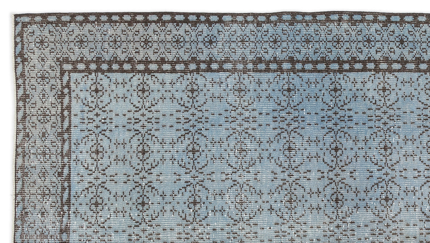 Light blue rug with a dark brown traditional floral medallion border and repeating geometric pattern.