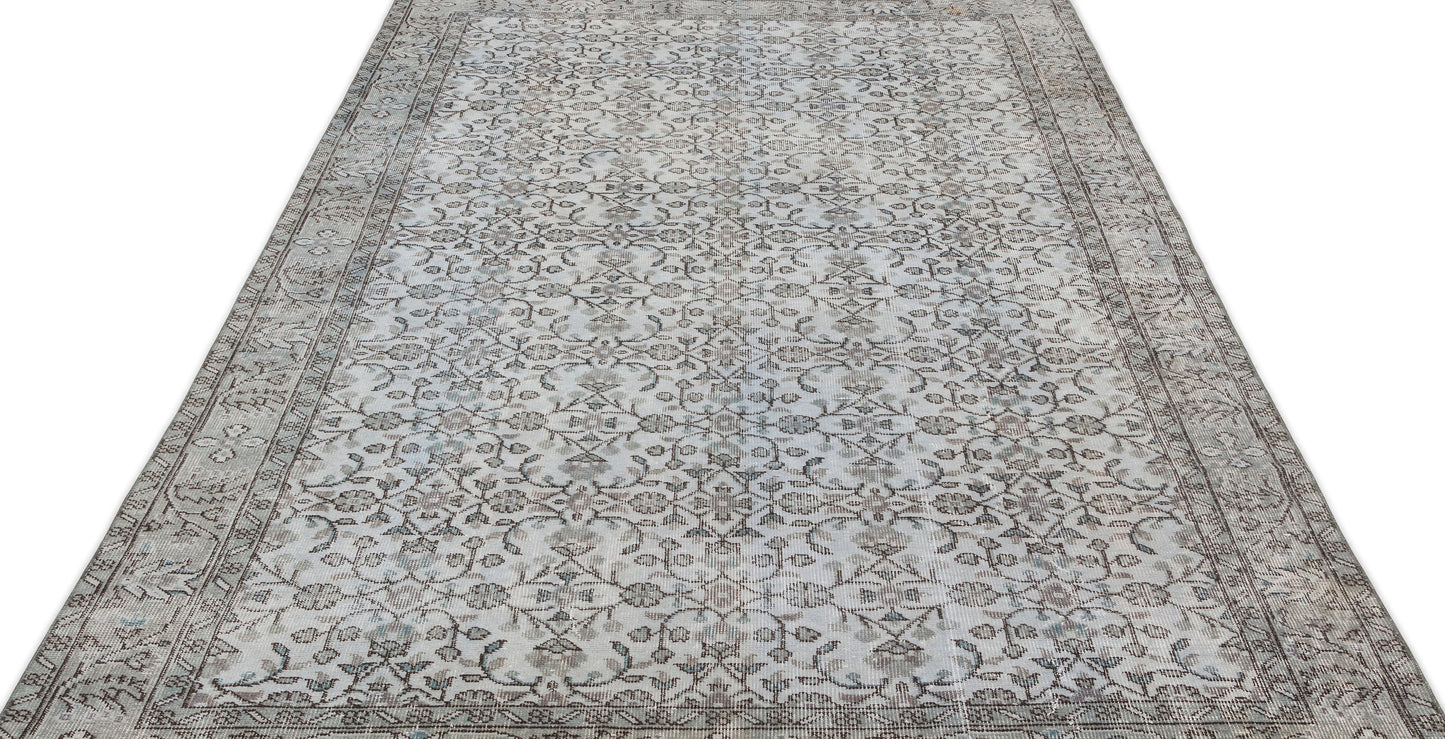 Grey and beige vintage-style rug with a repeating floral vine pattern and a decorative border on a white background.