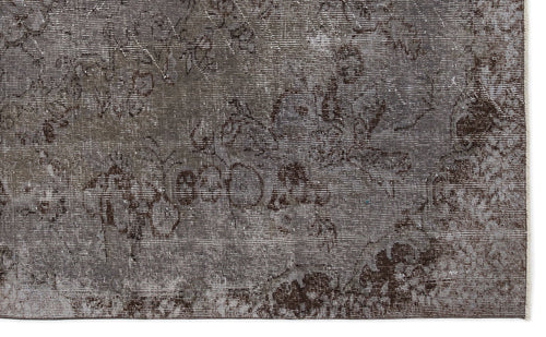 Load image 1 in gallery view. Dark gray and brown distressed rug with a faded traditional floral pattern.
