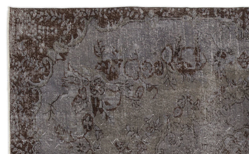 Load image 1 in gallery view. Dark brown and grey distressed rug with a faded traditional floral pattern.
