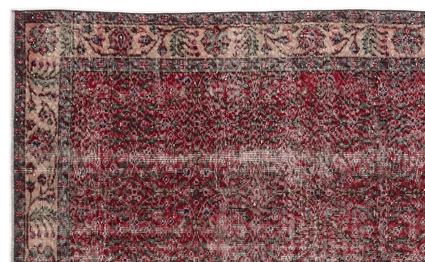 Distressed red and charcoal traditional rug with a floral medallion pattern and a decorative border.