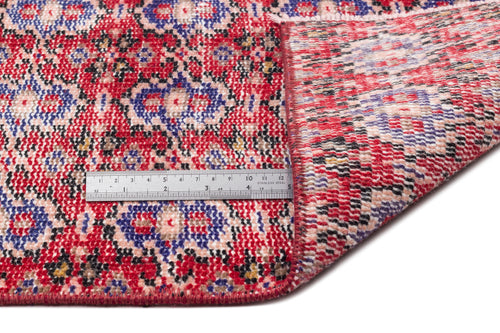 Load image 1 in gallery view. Red, blue, and black traditional floral medallion rug with a folded corner and a metal ruler for scale.