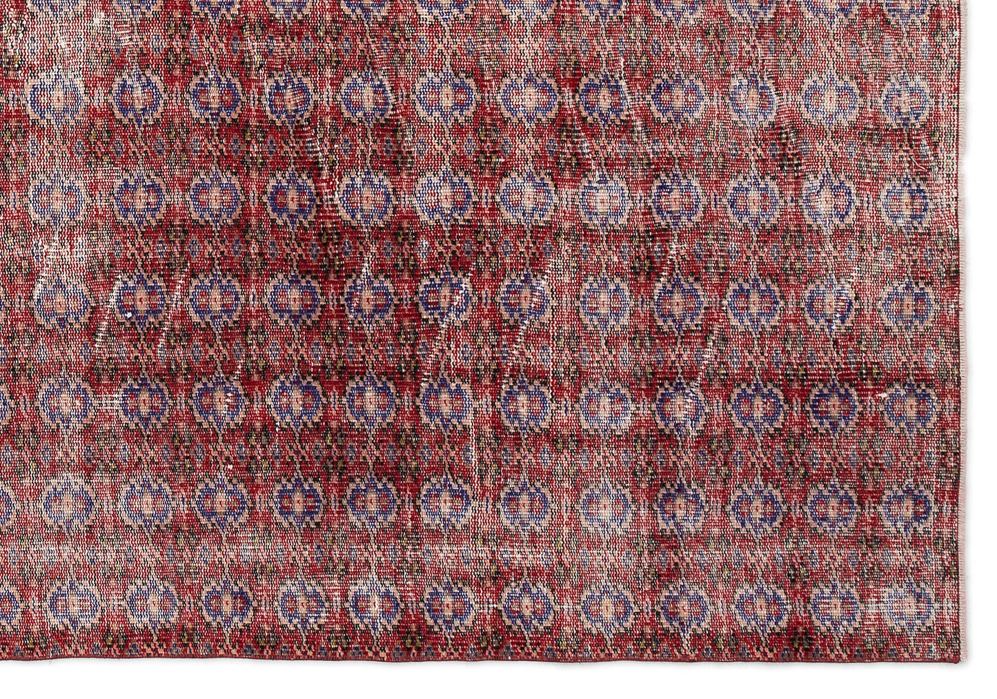 Red and blue distressed rug with a repeating geometric diamond and medallion pattern on a white background.
