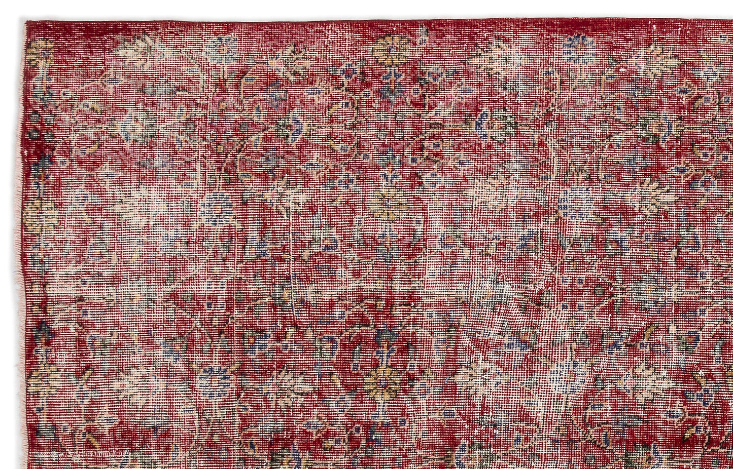 Distressed red rug with a faded floral medallion pattern in cream, blue, and yellow accents.