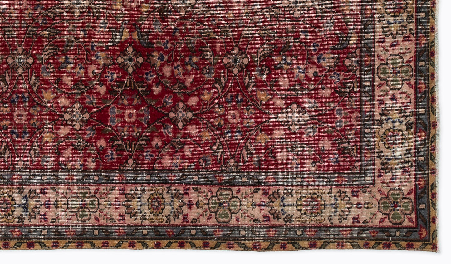 Deep red traditional rug with a distressed floral pattern and a beige border featuring intricate geometric motifs.