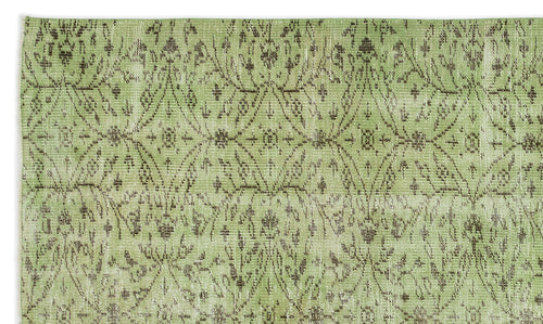 Load image 1 in gallery view. Sage green rug with a distressed, dark brown repeating diamond and floral medallion pattern.