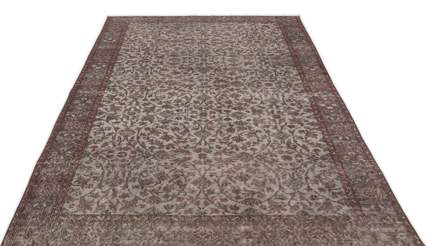Distressed brown and grey traditional rug with an intricate floral medallion pattern and a wide decorative border.