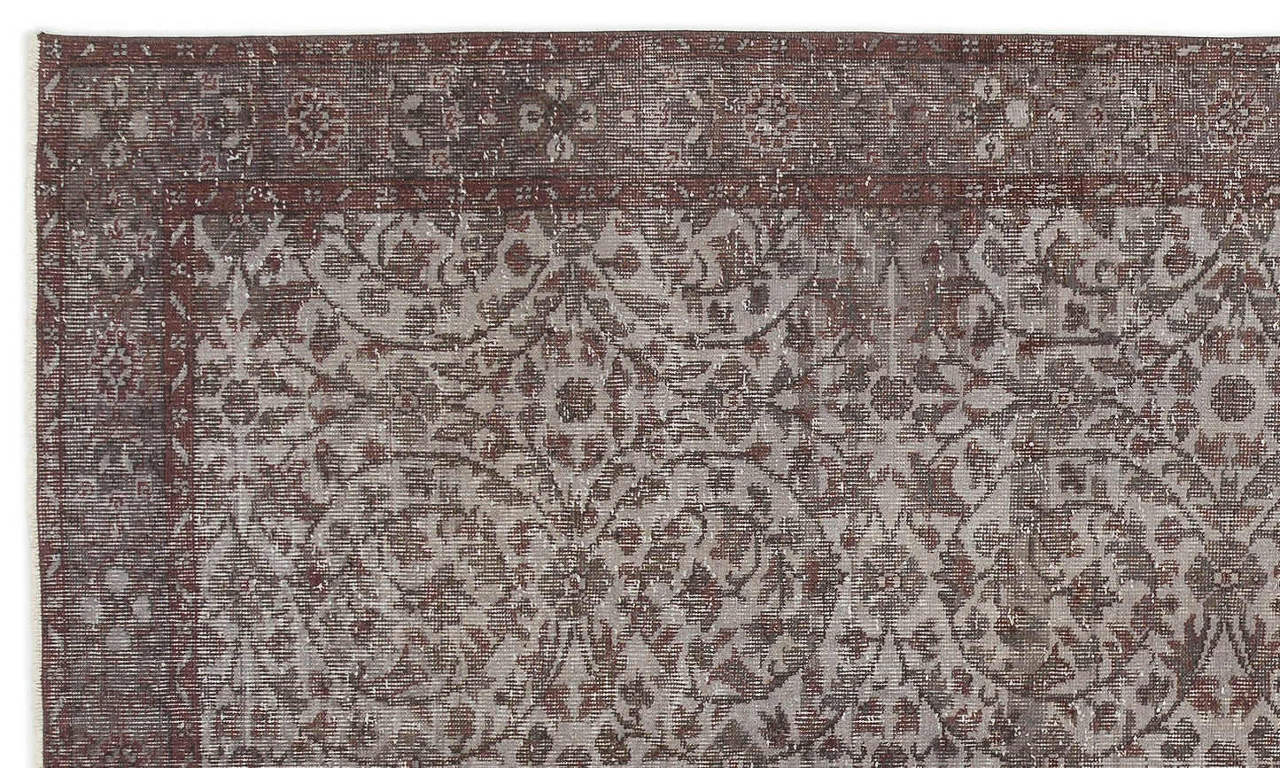 Distressed dark red and grey rug with a traditional floral medallion pattern and a wide decorative border.