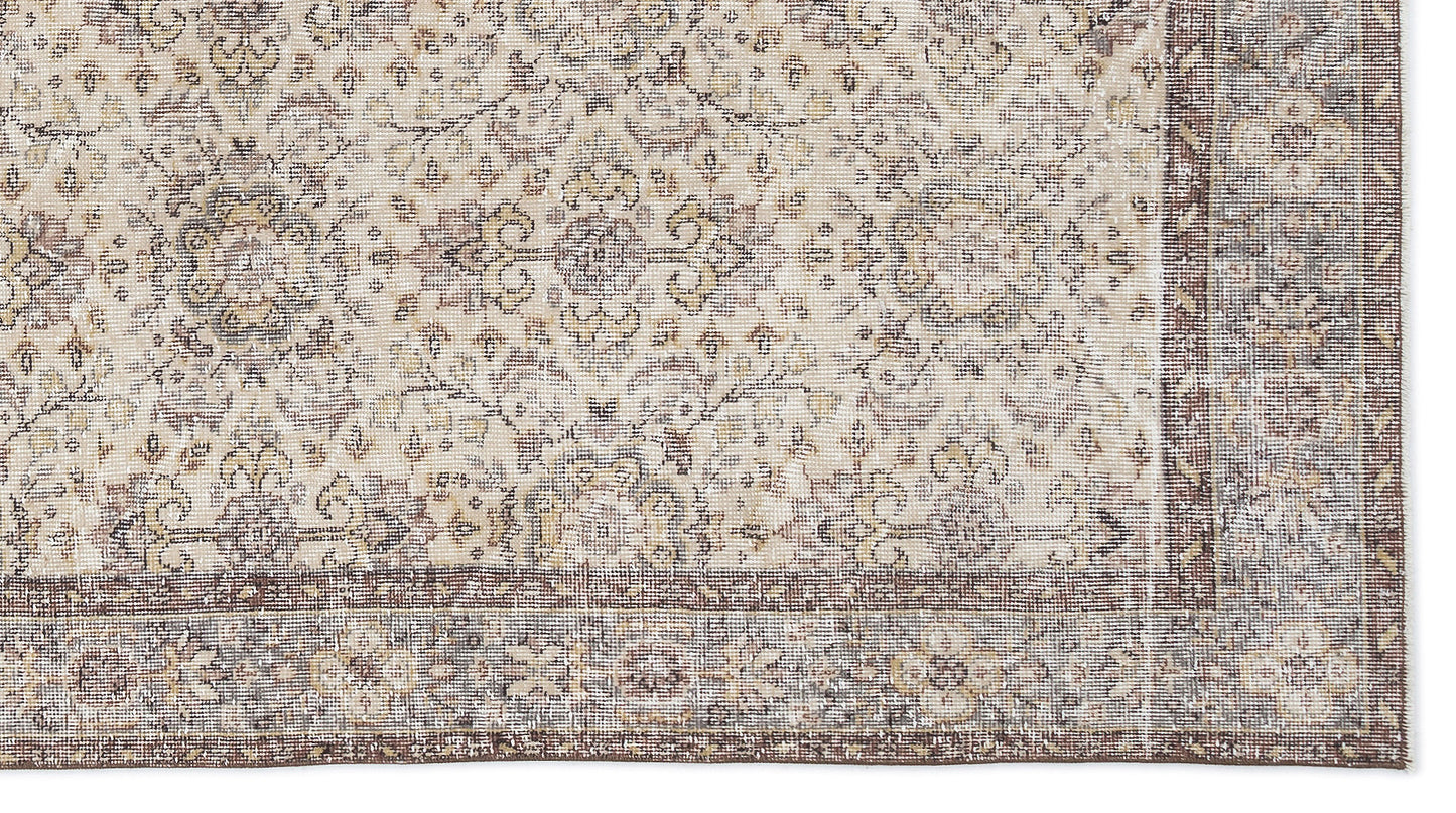 Beige and brown traditional rug with a distressed floral medallion pattern and a wide decorative border.