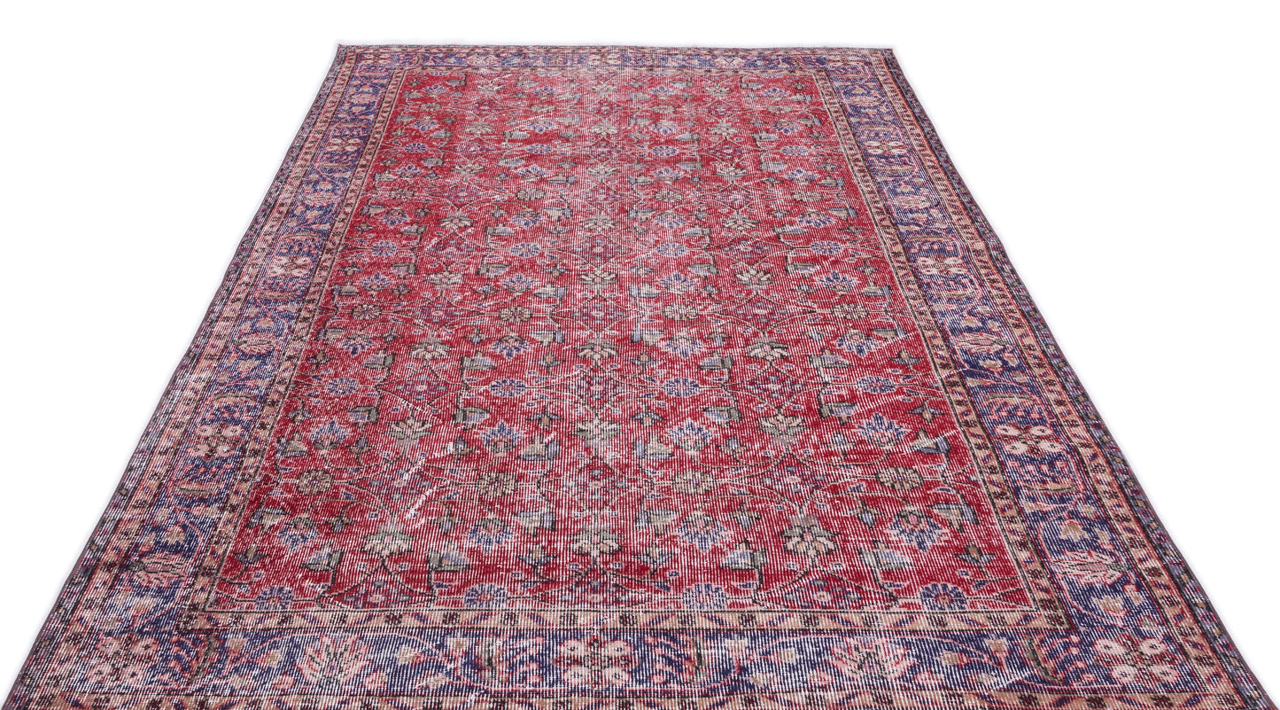 Red and blue traditional Persian-style rug with a distressed floral pattern and a wide decorative border.