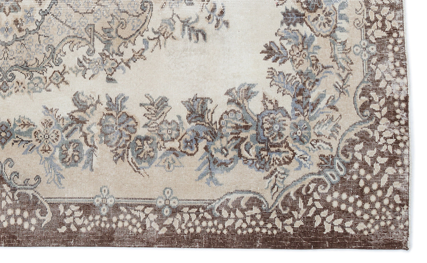 Beige rug with a distressed floral medallion pattern in shades of brown and slate blue.
