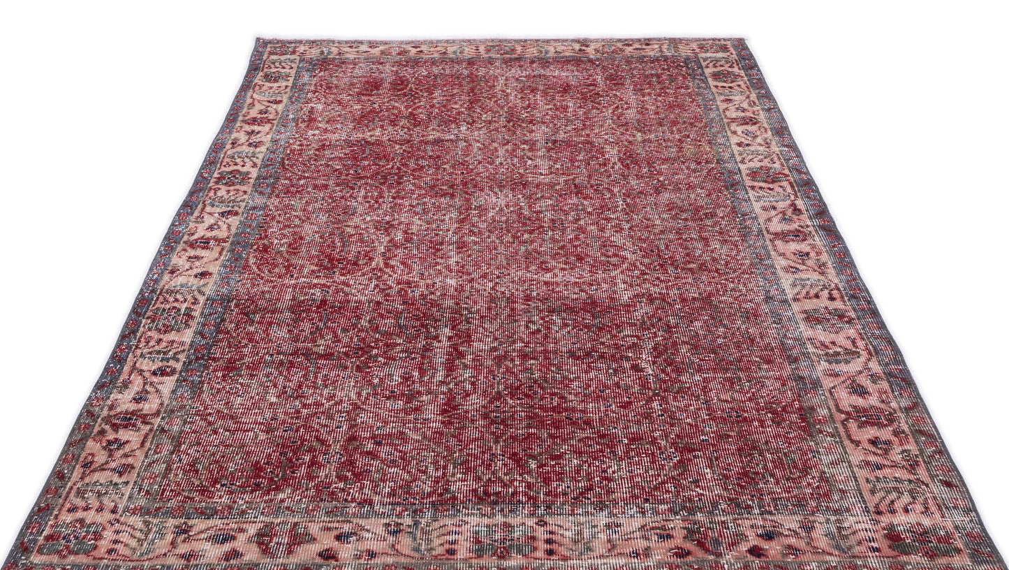 Distressed red and cream traditional rug with an intricate floral medallion pattern and a wide decorative border.