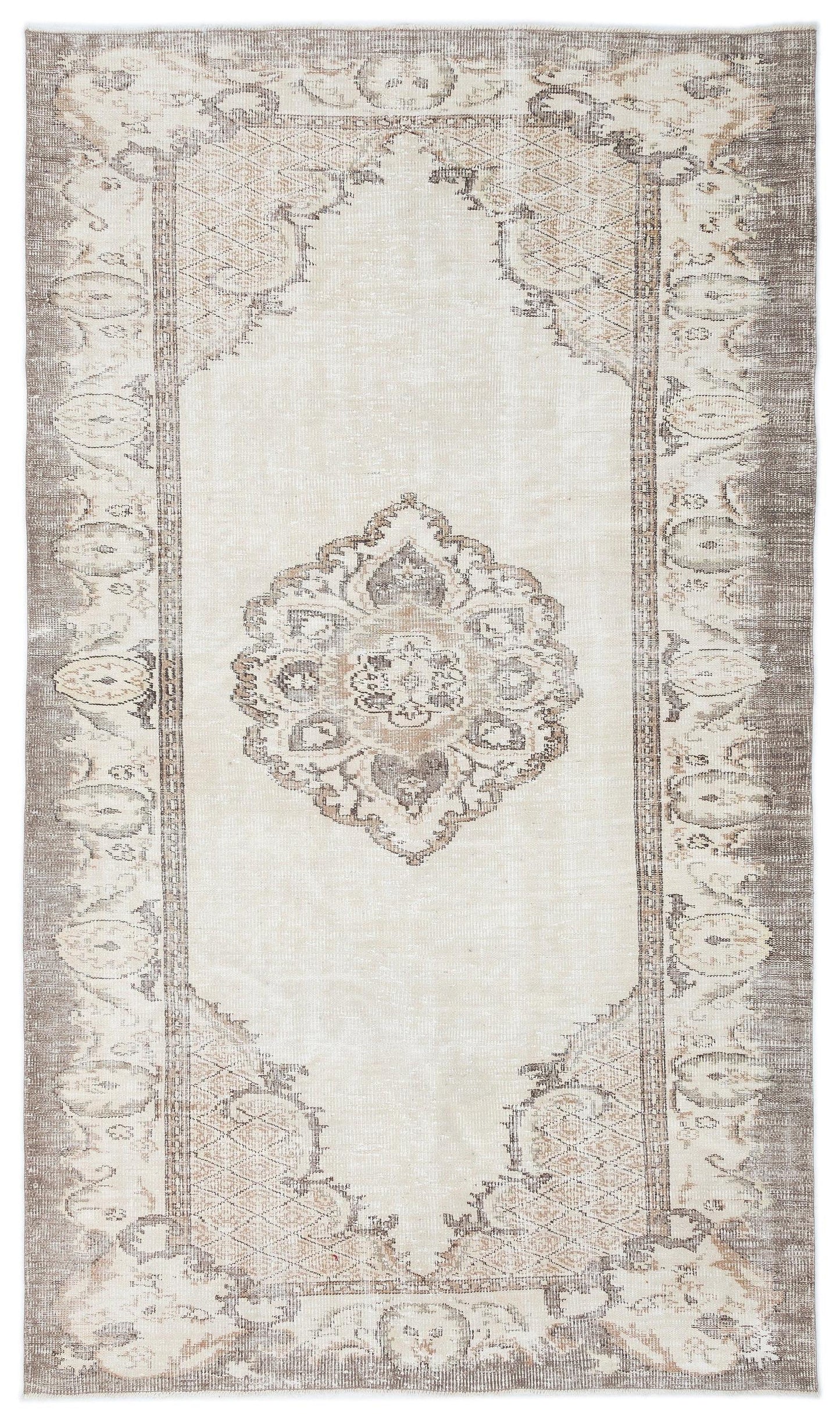 Cream and taupe distressed rug with a central floral medallion and ornate geometric border.