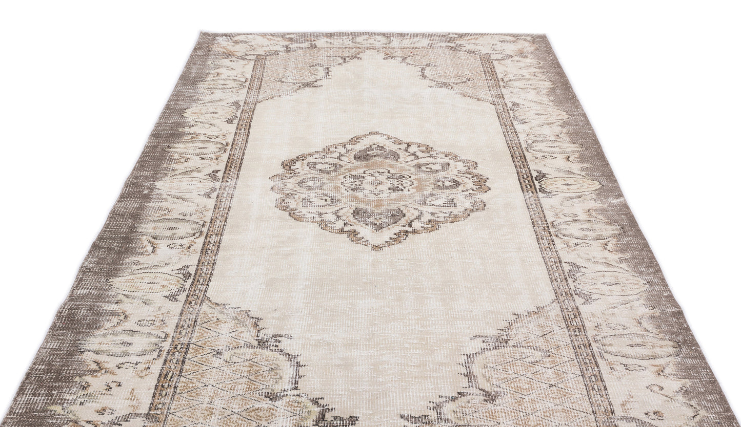 Beige and taupe distressed vintage-style rug with a central medallion and ornate border pattern on a white background.