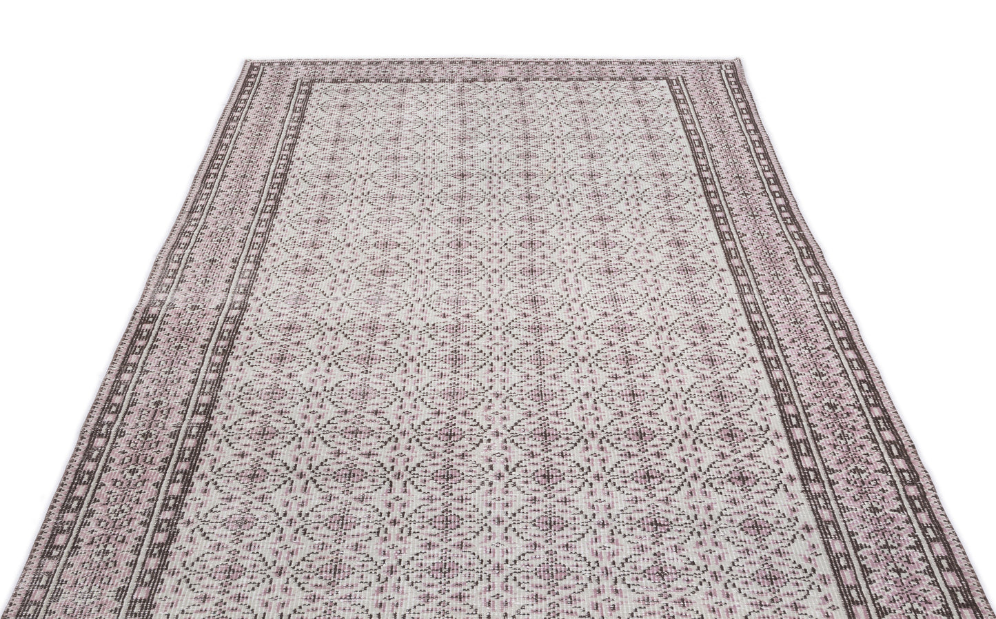 Cream and mauve area rug with a repeating geometric medallion pattern and a wide, detailed border.