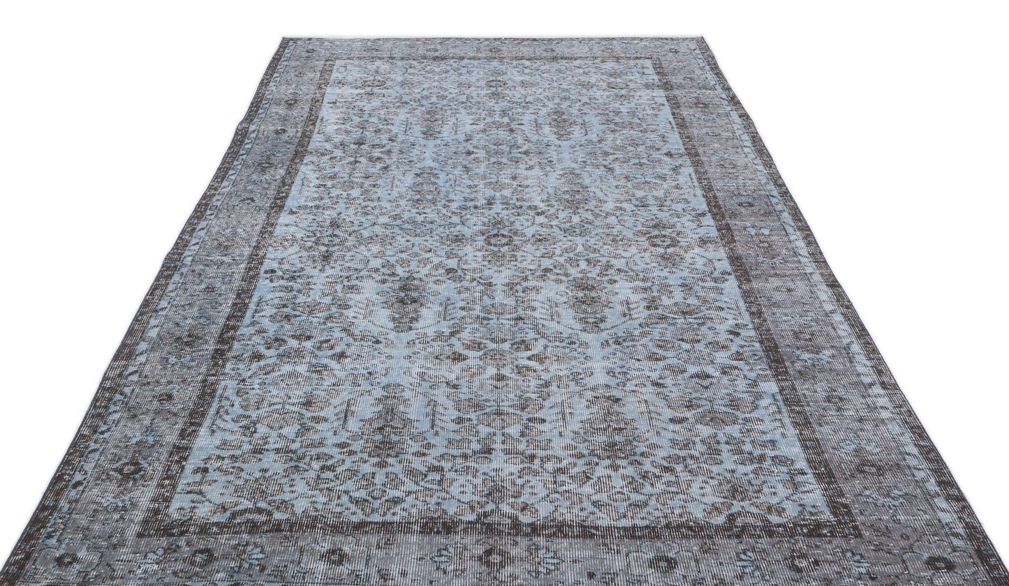 Light blue and charcoal grey distressed rug with a traditional ornate medallion pattern and a wide border.
