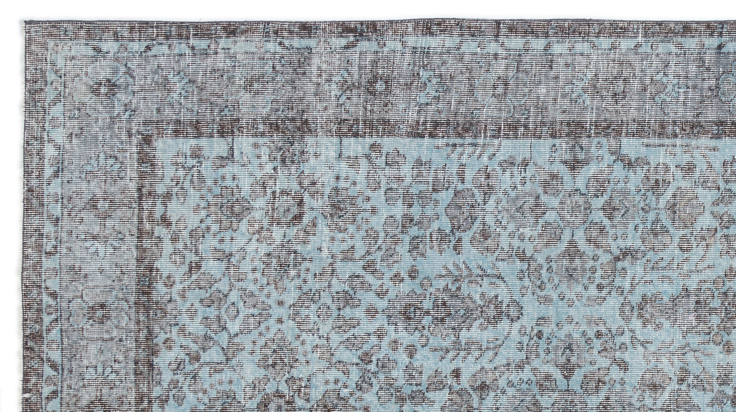 Distressed light blue and charcoal grey rug with a traditional floral medallion pattern and a wide border.