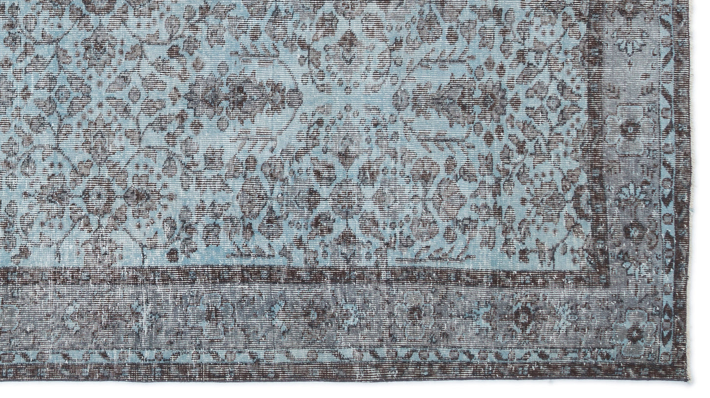 Light blue and charcoal grey rug with a distressed traditional floral medallion pattern and a wide decorative border.