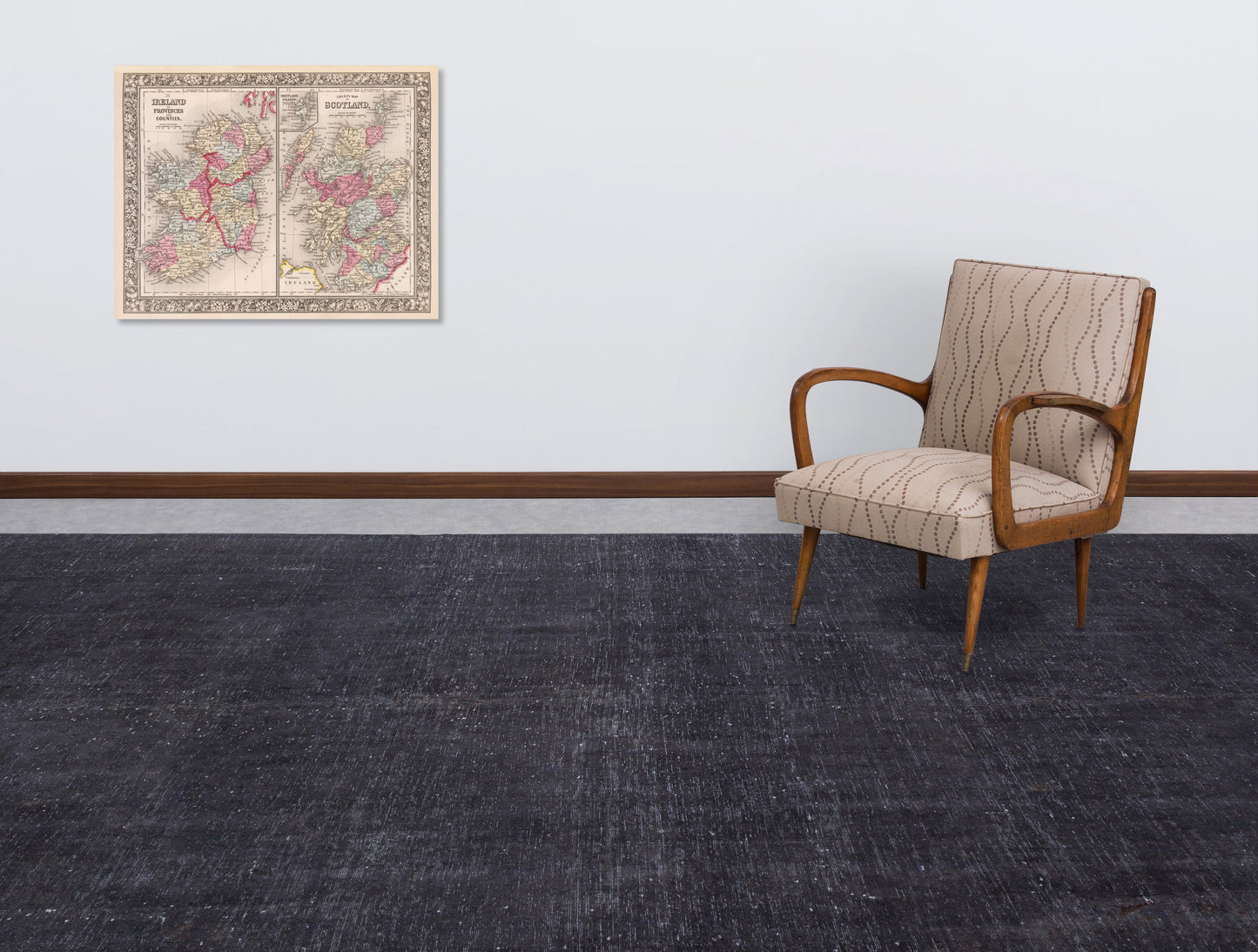 Solid charcoal grey rug with a distressed texture, styled in a room with a vintage armchair and wall map.
