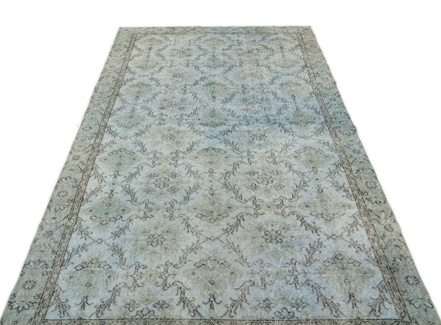 Light blue and grey distressed rug with a traditional floral medallion pattern and a decorative border.