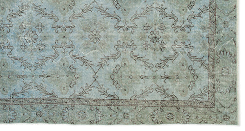 Load image 1 in gallery view. Light blue and sage green distressed rug with a faded traditional floral medallion pattern and a thin border.