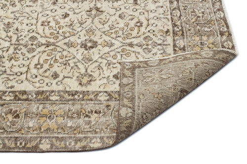 Load image 1 in gallery view. Beige and brown traditional floral rug with a folded corner revealing the woven backing on a white background.