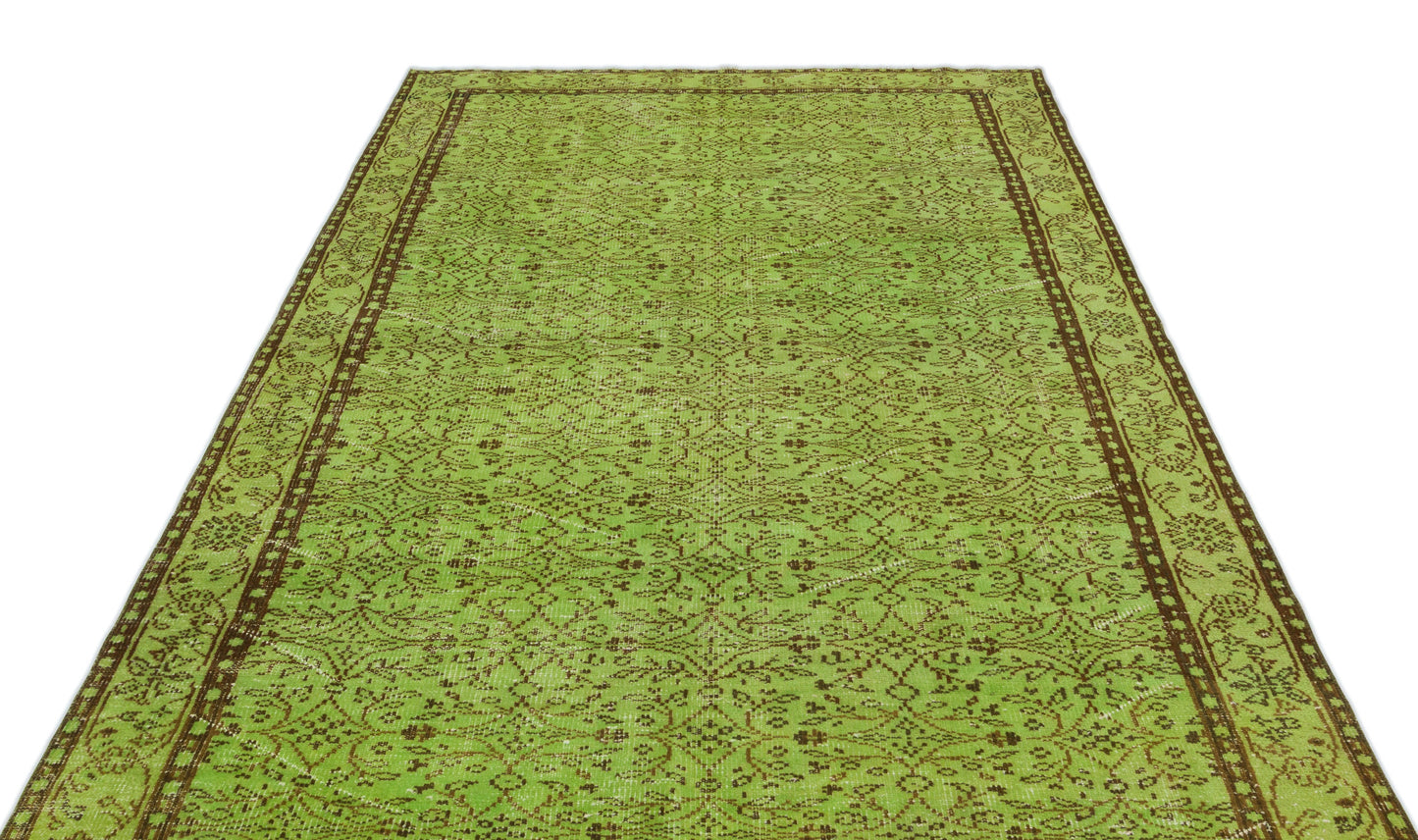 Lime green and brown vintage-style rug with a repeating floral medallion pattern and a decorative border.