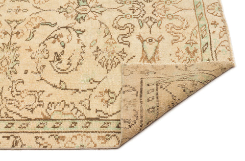 Load image 1 in gallery view. Beige and brown traditional rug with a faded floral medallion pattern and a folded corner, isolated on white.