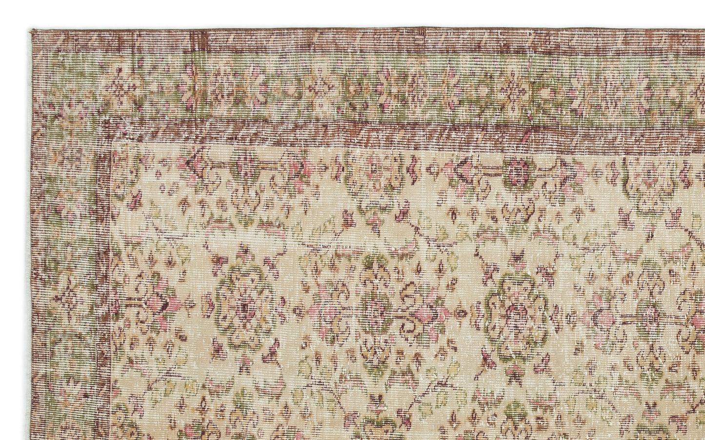 Distressed beige rug with a faded floral medallion pattern in muted pink, green, and brown tones.