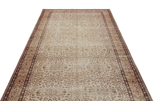 Load image 1 in gallery view. Beige and brown vintage-style rug with a distressed floral pattern and a geometric border on a white background.