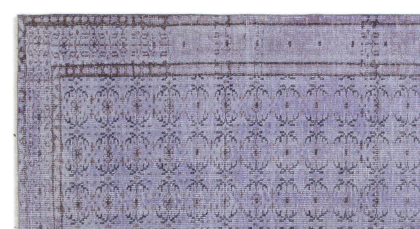 Lavender and dark brown vintage-style rug with a repeating floral medallion pattern and a decorative border.